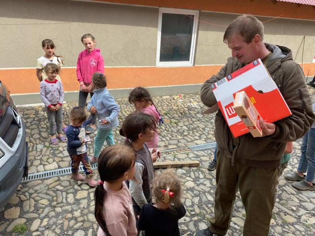 Zusammenarbeit mit Sozialwerken 16 15 Kinder freuen sich ueber Kekse von HOFFNUNG